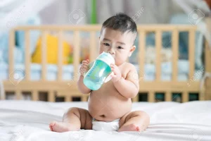 baby-drink-water-by-plastic-bottle-in-bed-room
